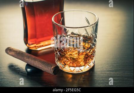 Alkoholisches Getränk, Whiskey und Zigarre auf braunem Holzhintergrund Stockfoto