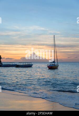 Soufriere, St. Lucia. Blick vom Strand über das Karibische Meer bei Sonnenuntergang, Boote vor der Küste, Anse Chastanet, verankert. Stockfoto