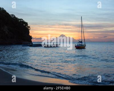 Soufriere, St. Lucia. Blick vom Strand über das Karibische Meer bei Sonnenuntergang, Boote vor der Küste, Anse Chastanet, verankert. Stockfoto