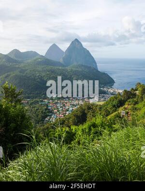 Soufriere, St. Lucia. Blick auf die Pitons von einem steilen bewaldeten Hügel über der Stadt. Stockfoto
