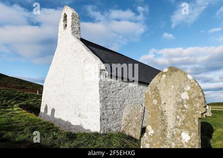 13thC Church of the Holy Cross, eine denkmalgeschützte Pfarrkirche am beliebten Strand von Mwnt - beide sind lokale Touristenattraktionen; Mwnt, Ceredigion, Wales, Großbritannien Stockfoto