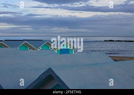 Eine Reihe von blauen Strandhütten an der Mittelmeerküste in den Abendstunden (Pesaro, Marken, Italien) Stockfoto