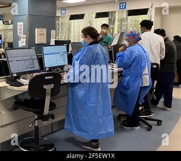 Krankenschwestern und Ärzte geben während der Pandemie Covid-19 in New York City Informationen und Daten über Patienten in einer sehr geschäftigen Notaufnahme des Krankenhauses ein. Stockfoto