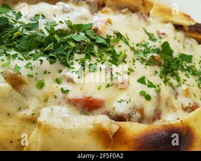 Traditionelle türkische Küche Kasarli Pide Boot-geformtes Fladenbrot mit Käse, Gewürzen und Kräutern Food Photography Stockfoto