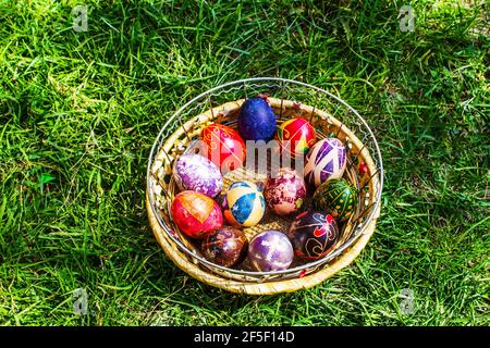Defokussieren Sie bunte ostereier. Dekoriert pysanka und krashanka. Holzkorb Mit Ostereiern Im Grünen Gras. Nahaufnahme. Festlich. Traditionell Stockfoto