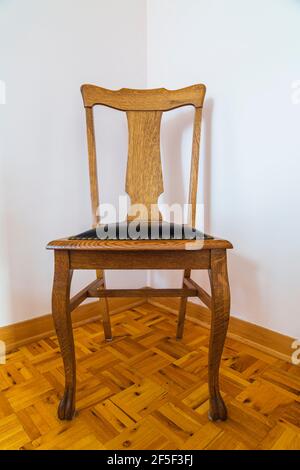 Massiver Stuhl aus rotem Eichenholz mit hoher Rückenlehne und genietetem Schwarz Ledersitz im Gästeschlafzimmer mit eingelegtem Hartholzboden innen Ein altes Haus im Cottage-Stil von 1807 Stockfoto