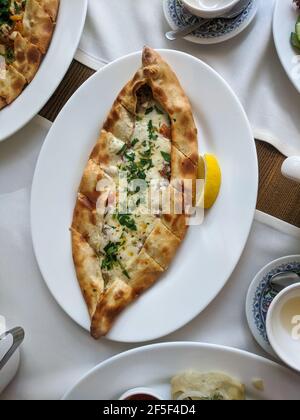 Traditionelle türkische Küche Kasarli Pide Boot-geformtes Fladenbrot mit Käse, Gewürzen und Kräutern Food Photography Stockfoto