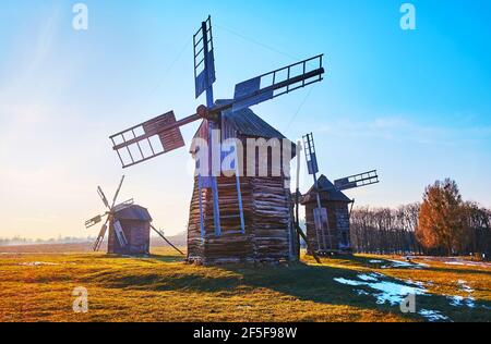 Genießen Sie den sonnigen Tag im frühen Frühjahr in Pyrohiv Skansenmit Blick auf die Holzwindmühlen aus der Region Polissya, Kiew, Ukraine Stockfoto