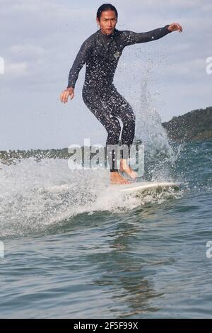 (210326) -- SANYA, 26. März 2021 (Xinhua) -- das Foto vom 27. Februar 2021 zeigt, wie TU Hongwei im Dorf Tanya in Tenghai, südchinesischer Provinz Hainan, das Surfen praktiziert. Das Dorf Tenghai, einst ein kleines Fischerdorf, ist seit dem Surfboom in China ein berühmtes Surfcamp geworden, nachdem es offiziell für das Programm der Olympischen Spiele 2020 in Tokio zugelassen wurde. Das Dorf liegt in Sanya, der südchinesischen Provinz Hainan, und gewann auch Anerkennung für seine großartige Kombination aus Wassersport und Tourismusindustrie.Yang Xingfu, ein örtlicher Dorfbewohner, ist einer der frühesten Surfer in Tenghai. Yang verlobt mich einmal Stockfoto