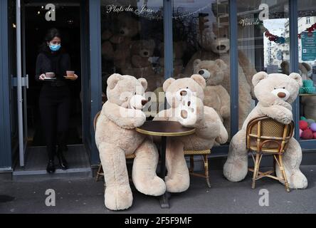 Paris, Frankreich. März 2021, 26th. Der Besitzer des Bouquet Wagram Cafés, das Take Away Services anbietet, serviert Kaffee für riesige Teddybären in Paris, Frankreich, 26. März 2021. Der französische Gesundheitsminister Olivier Veran kündigte am Donnerstag "Zwangsbremsungsmaßnahmen" in drei weiteren COVID-19-Hochrisikoregionen - Rhone, Aube und Nievre - an, um eine dritte Welle der Pandemie einzudämmen. Kredit: Gao Jing/Xinhua/Alamy Live Nachrichten Stockfoto