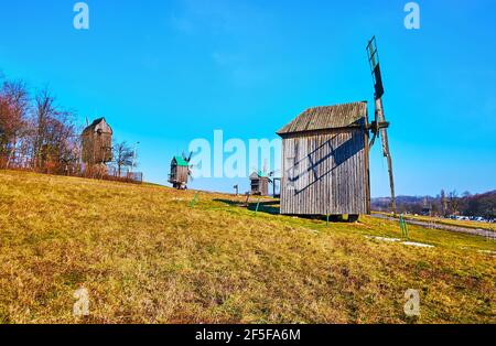 Traditionelle Holzwindmühlen auf dem Hang in Pyrohiv Skansen, Kiew, Ukraine Stockfoto