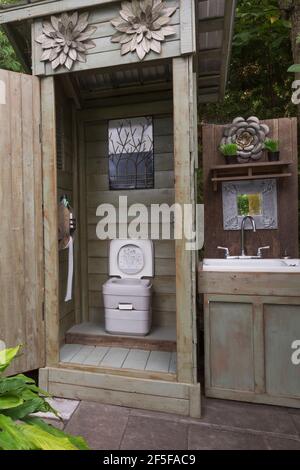 Holzdiele Nebengebäude mit Handspülung tragbare Toilette und Holz Schrank mit Waschbecken im Garten Stockfoto