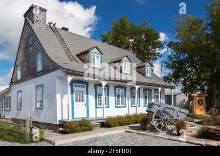 Alt um 1790 weiß bemaltes vertikales Kiefernholz mit Blau Trimmen Sie die Fassade des Hauses im kanadischen Cottage-Stil mit grauem Blech Dach im Sommer Stockfoto