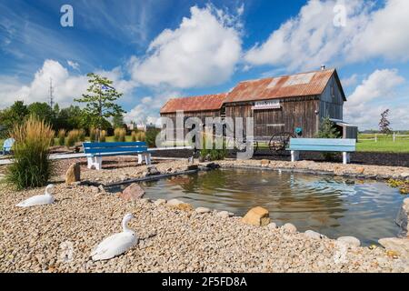 Künstlich anbauter Teich mit Sitzbänken und alten Holzdielen Im Hinterhof des alten Hauses Stockfoto