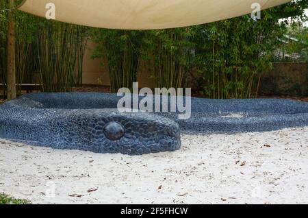 Hängematte Hollow Children's Garden, Indigo Pass, schwarzer Kieselstein Mosaik Schlange Skulptur umgibt Sandkreis, spielen, Entdeckung-basierte Lernen, Spaß, einzigartig Stockfoto