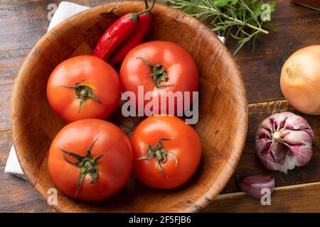 Tomaten, Knoblauch, Paprika und Kräuter über Holztisch. Stockfoto