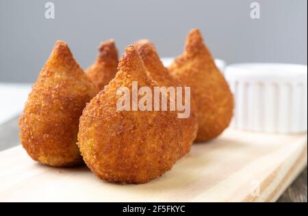 Typisch brasilianische Snack coxinha auf einem Holzbrett. Stockfoto