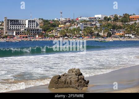 Touristen am Sandstrand und Hotels am Playa Principal in der Nähe von Puerto Escondido, San Pedro Mixtepec, Oaxaca, Mexiko Stockfoto