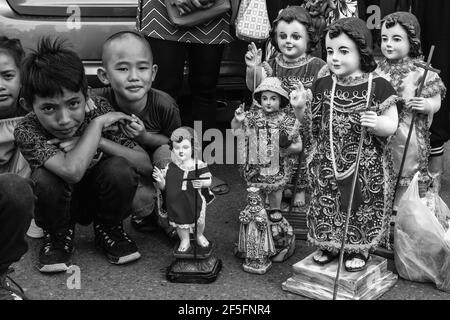 Lokale Kinder Warten Mit Ihren Santo Nino Statuen Auf Die Ankunft Auf Dem Meer Der Replik Santo Nino De Cebu, Dinagyang Festival, Iloilo, Philippinen. Stockfoto
