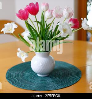 Ein kleines buntes Bündel Tulpen in einer Vase auf Die Tabelle Stockfoto