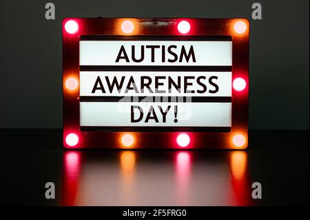 Leuchtkasten mit roten Lichtern mit Worten - Autismus-Tag! Der Welt-Autismus-Tag ist ein international anerkannter Tag, der jedes Jahr am 2. April stattfindet. Stockfoto