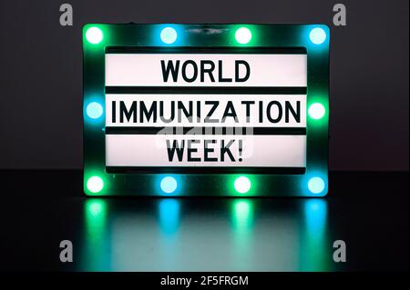 Leuchtkasten mit grünen Lichtern mit Wörtern - World Immunization Week! Stockfoto