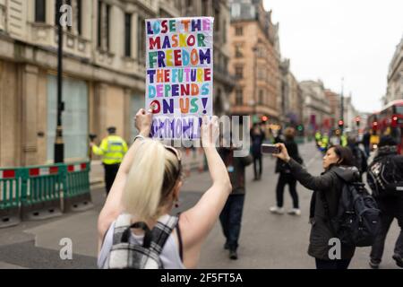 Anti-Lockdown und Anti-Covid-19-Impfprotest, London, 20. März 2021. Marschierende Protestierenden mit Plakat. Stockfoto