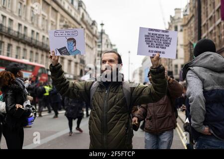 Anti-Lockdown und Anti-Covid-19-Impfprotest, London, 20. März 2021. Protestler mit zwei Plakaten. Stockfoto