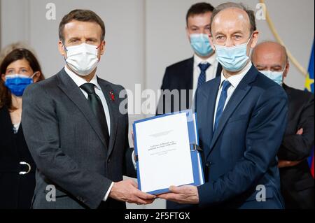 Paris, Frankreich. März 2021, 26th. Der französische Präsident Emmanuel Macron hält gemeinsam ein Dokument zusammen mit dem Historiker Vincent Duclert, der am 26. März 2021 im Salle des Fete im Elysée-Palast in Paris, Frankreich, die ruandische kommission und sein Team (dahinter) leitet. Foto von Eric Tschaen/Pool/ABACAPRESS.COM Quelle: Abaca Press/Alamy Live News Stockfoto