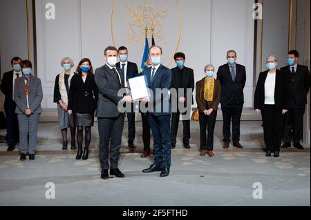 Paris, Frankreich. März 2021, 26th. Der französische Präsident Emmanuel Macron hält gemeinsam ein Dokument zusammen mit dem Historiker Vincent Duclert, der am 26. März 2021 im Salle des Fete im Elysée-Palast in Paris, Frankreich, die ruandische kommission und sein Team (dahinter) leitet. Foto von Eric Tschaen/Pool/ABACAPRESS.COM Quelle: Abaca Press/Alamy Live News Stockfoto