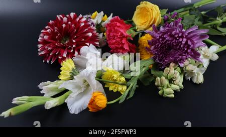 Bouquet von natürlichen Blumen isoliert auf dunklem Hintergrund, schöne, bunte Blumen Stockfoto