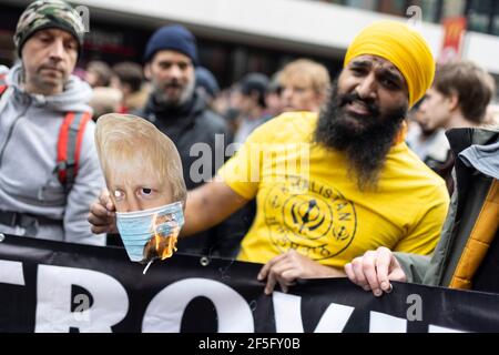 Anti-Lockdown und Anti-Covid-19-Impfprotest, London, 20. März 2021. Demonstranten verbrennen eine Gesichtsmaske von Boris Johnson. Stockfoto