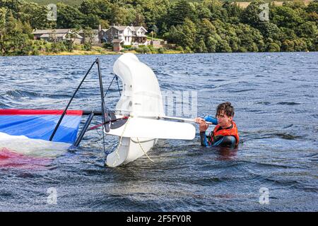 The English Lake District - Segeln auf Ullswater, Cumbria UK - EIN junger Mann, der nach dem Kentern gerade ein Schlauchboot nach rechts macht Stockfoto