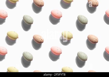 Draufsicht Dekoration Frohe Ostern Urlaub Hintergrundkonzept. Flach legen bunte Pastelleier auf weißem Papier nahtlose Muster. Stockfoto