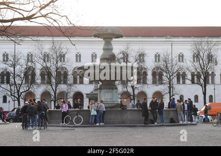 München, Deutschland. März 2021, 26th. Viele Menschen tummeln sich am Brunnen der Universität bei warmen Temperaturen in den Abendstunden. Quelle: Felix Hörhager/dpa/Alamy Live News Stockfoto