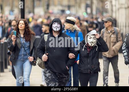 Anti-Lockdown und Anti-Covid-19-Impfprotest, London, 20. März 2021. Marschierende Demonstranten in Guy Fawkes Masken. Stockfoto