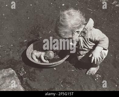 Ein Kind wandernder Packhausarbeiter, die ihre Puppe waschen, Belle Glade, Florida. Marion Post Wolcott (Amerikanisch, 1910 - 1990) Stockfoto