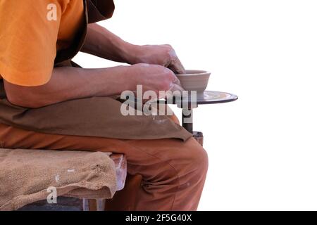 Potter in braun Schürze macht Ton Keramik auf Kreis. Handwerkliches Konzept. Isoliert auf weißem Hintergrund. Stockfoto