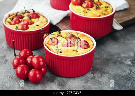 Mini Quiche Pie mit Hühnerfleisch, Käse und Tomaten in Backformen. Stockfoto