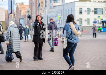 Moskau. Russland. März 26, 2021. Eine Frau verteilt Flyer an Passanten auf der Straße. Frühlingstag in der Stadt. Stockfoto