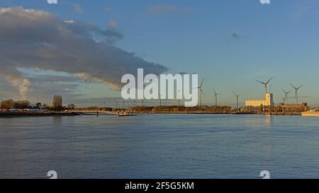 Dock im Hafen von Antwerpen, Belgien, mit alten Industriegebäuden und Windkraftanlagen in warmen Abendsonne Licht Stockfoto