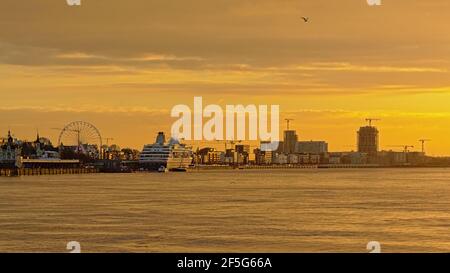 Kais des Flusses Schelde in Antwerpen, mit historischem Hafengebäude, Riesenrad, Wolkenkratzern und Kreuzfahrtschiff im trüben Abendlicht Stockfoto