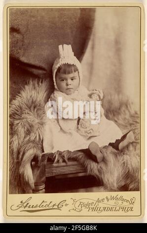 Baby Mädchen in Haube, sitzend, hält eine Puppe. A. Husted & Company Stockfoto