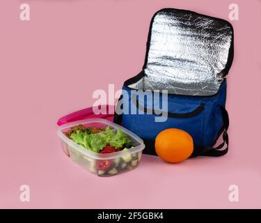 Thermobeutel und Behälter mit Salat, Fleisch und Orange. Hausgemachtes Mittagessen zum Mitnehmen. Stockfoto