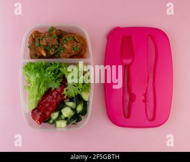 Behälter mit Salat, Fleisch und Orange. Hausgemachtes Mittagessen zum Mitnehmen. Stockfoto