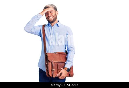 Junger schöner blonder Mann trägt elegantes Hemd mit Aktentasche gestresst und frustriert mit Hand auf Kopf, überrascht und wütend Gesicht Stockfoto