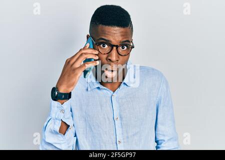 Junger afroamerikanischer Mann mit Gespräch auf dem Smartphone Angst und erstaunt mit offenem Mund für Überraschung, Unglauben Gesicht Stockfoto