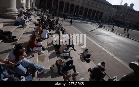 München, Deutschland. März 2021, 26th. Passanten sitzen auf den Stufen der Bayerischen Staatsoper am Max-Joseph-Platz. Kredit: Peter Kneffel/dpa/Alamy Live Nachrichten Stockfoto