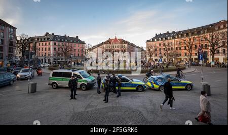 München, Deutschland. März 2021, 26th. Polizisten stehen am Gärtnerplatz im Herzen der Stadt, während Passanten auf dem Platz verweilen. Kredit: Peter Kneffel/dpa/Alamy Live Nachrichten Stockfoto