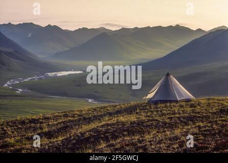 Backpacking Zelt mit Blick auf ein Flusstal in der arktischen Tundra von Gates of the Arctic National Park, Brooks Range, Alaska, USA Stockfoto